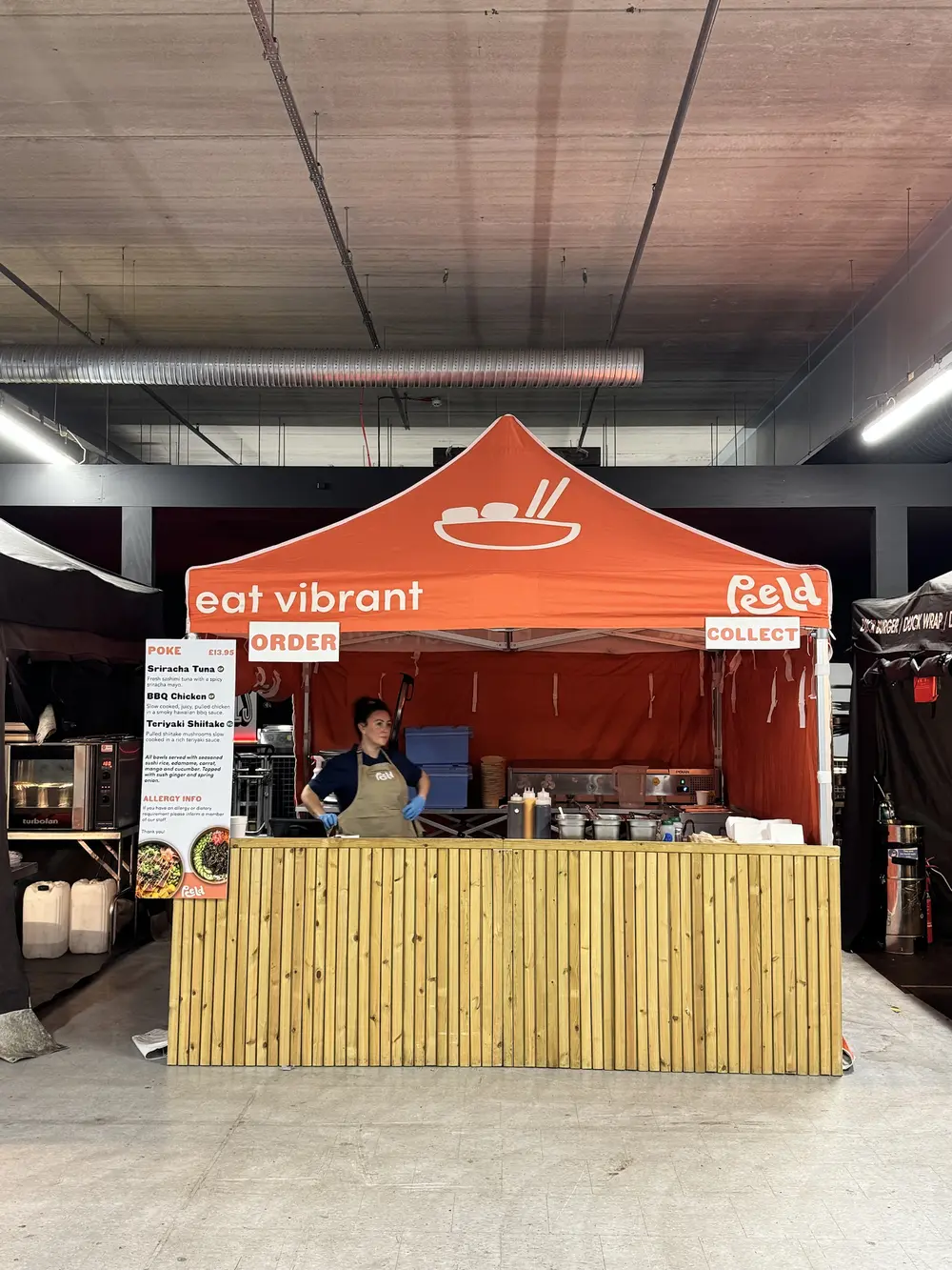 The Peeld gazebo stall with its eat vibrant canopy and timber counter at an indoor food hall
